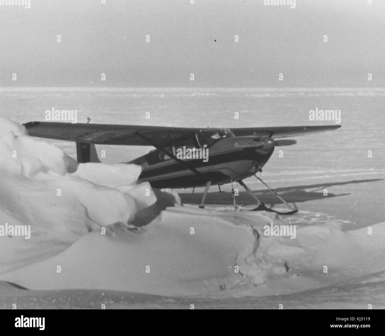 Un piccolo aereo dotato di sci è mostrato sulla neve, probabilmente in una regione fredda. Questa configurazione è stata progettata per volare in condizioni di neve o ghiaccio, in cui le ruote convenzionali non sarebbero praticabili. Foto Stock