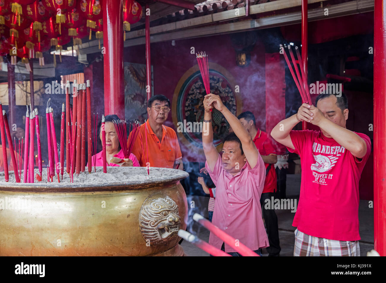 Gli indonesiani cinesi adorando bruciando incenso all'interno cinese tempio buddista a Jakarta, Indonesia Foto Stock