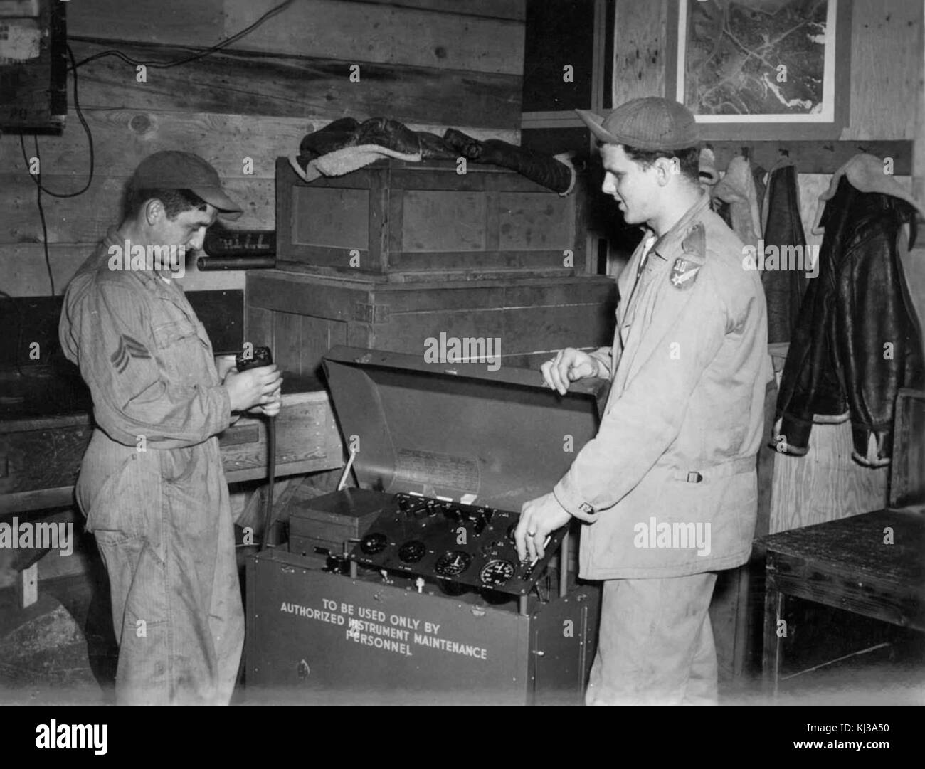 L'immagine raffigura due uomini impegnati in lavori manuali all'interno di un'officina, evidenziando il loro impiego in attività industriali o artigianali. Foto Stock