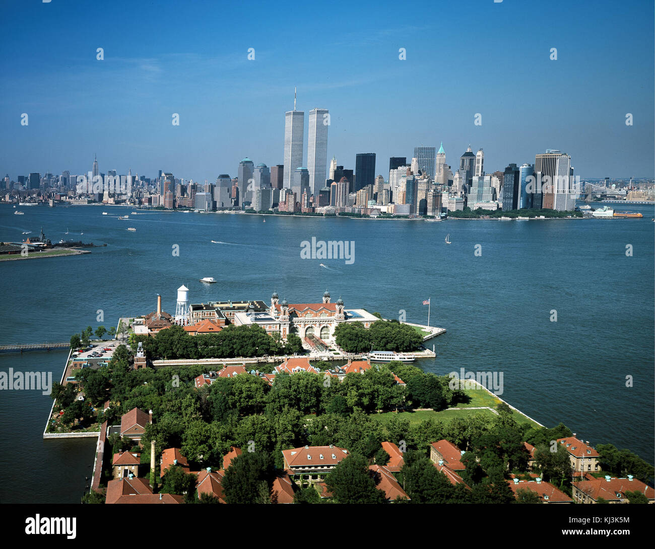 Questa fotografia cattura il complesso di Ellis Island e lo skyline di Lower Manhattan, scattati prima degli eventi dell'11 settembre 2001, che mostrano lo storico sito di immigrazione di New York. Foto Stock