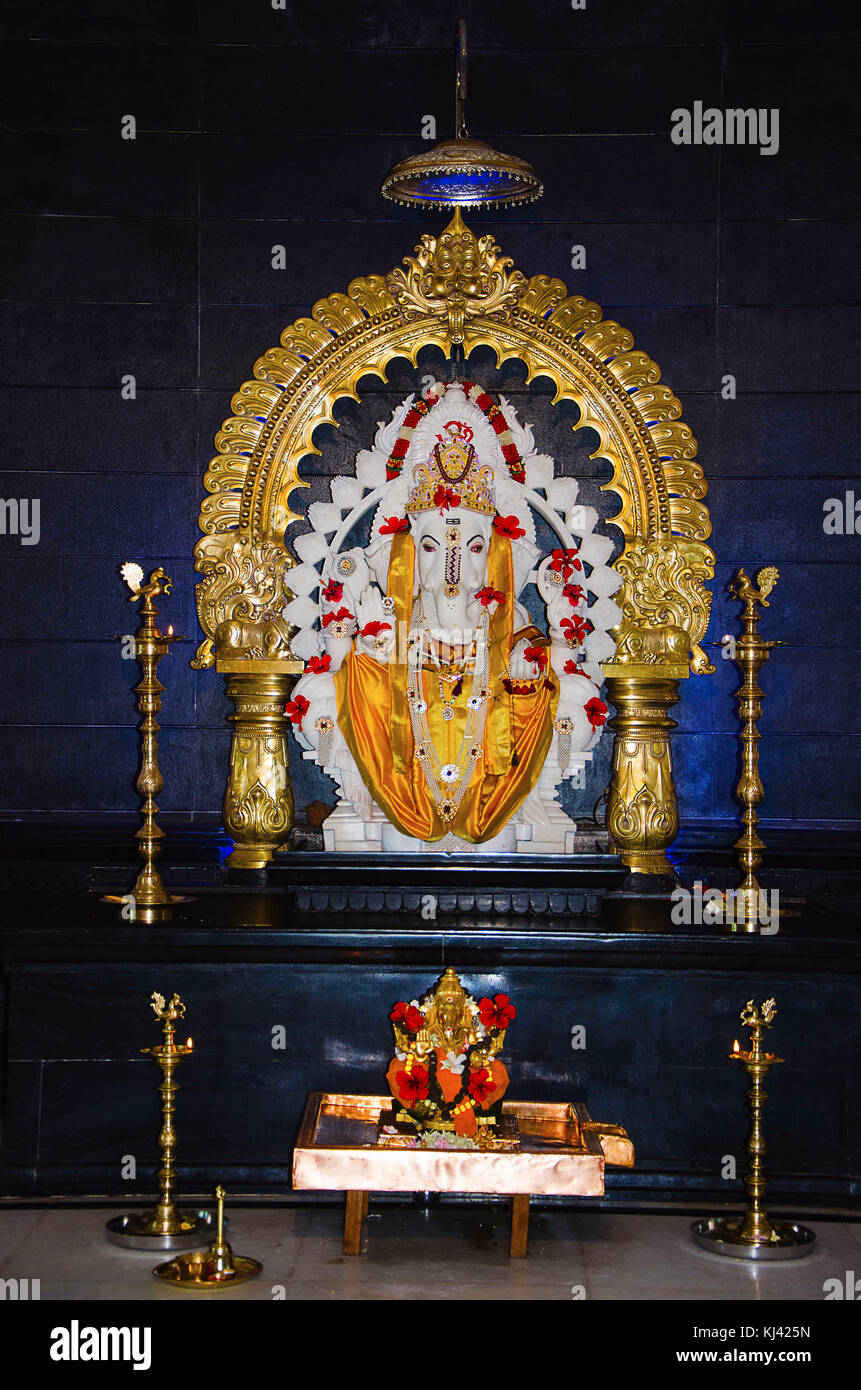 Idolo in marmo bianco Lord Ganesh con prabhaval decorativo in ottone e quattro lampade tradizionali. Pranav Ganesh Mandir, Pune, Maharashtra, India Foto Stock