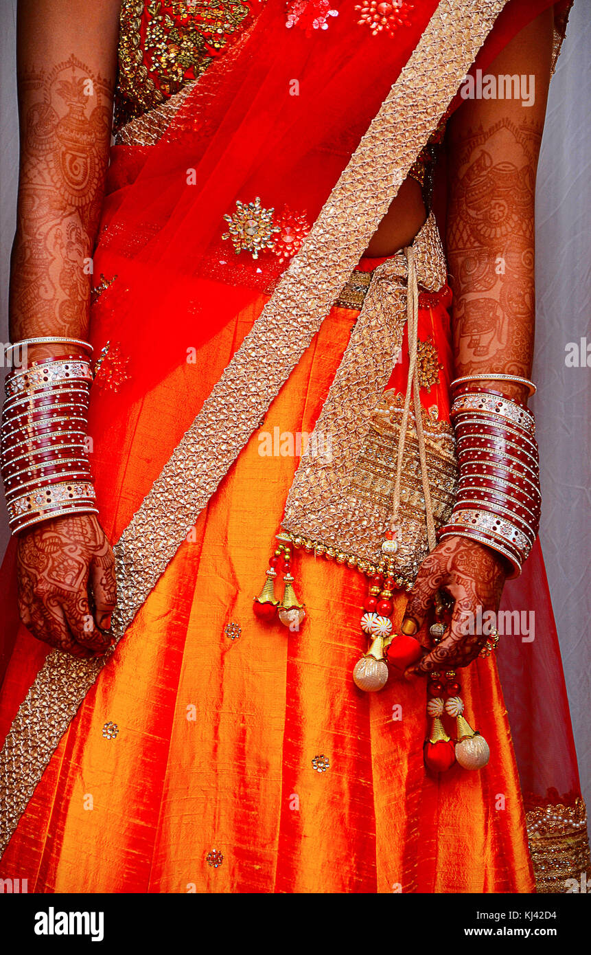 Primo piano di una sposa che indossa un bellissimo Ghagra-choli di seta di colore arancione con bordo in argento. Pune, Maharashtra, India Foto Stock
