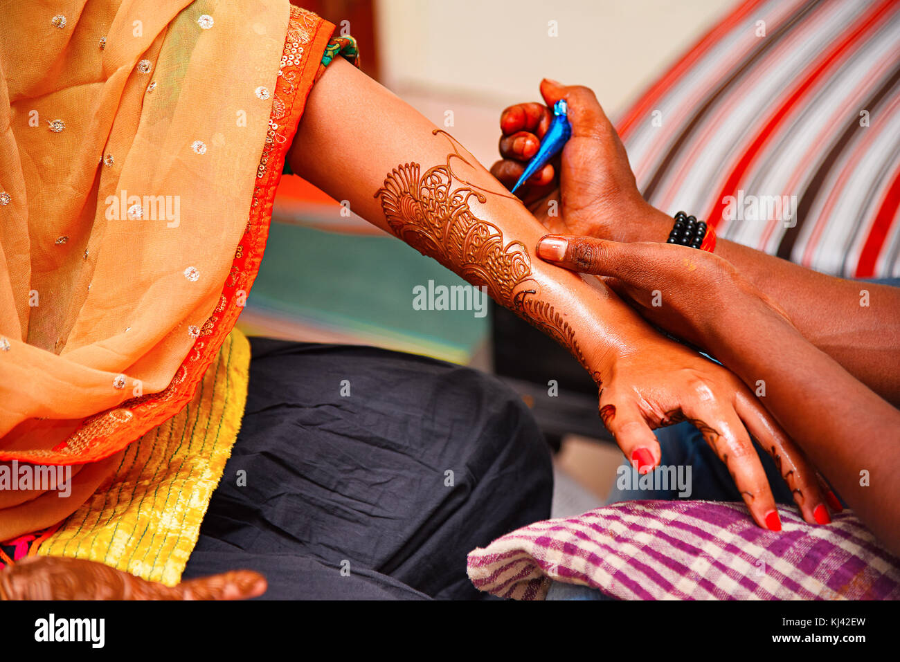 Artista Mehndi (Henna Tattoos) che disegna mehndi sulla mano sinistra di una signora in un evento culturale, Pune, Maharashtra, India Foto Stock