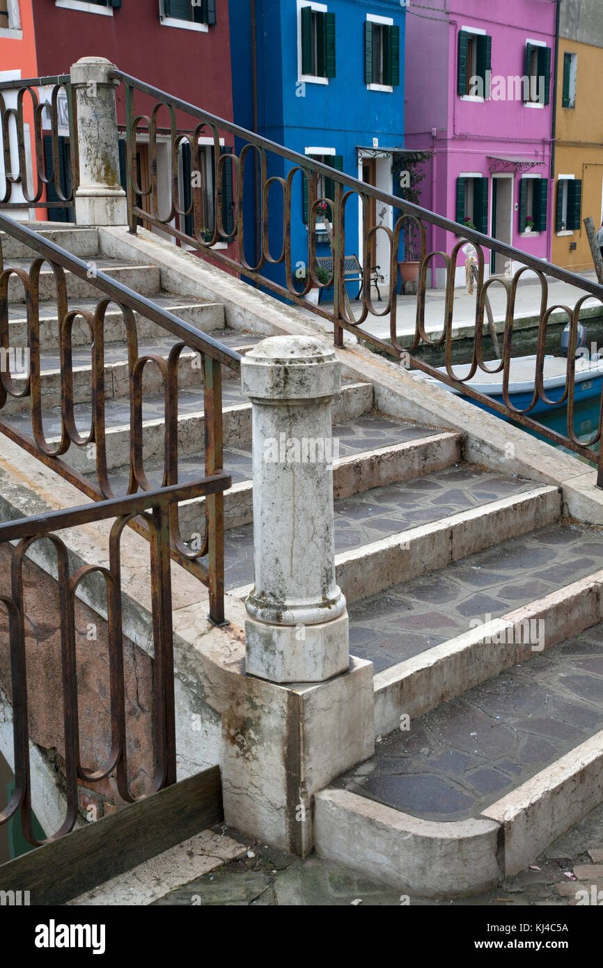 Vivacemente colorato marrone, blu, rosa, giallo case con ponte con ringhiere in metallo a Burano Venezia Italia Foto Stock