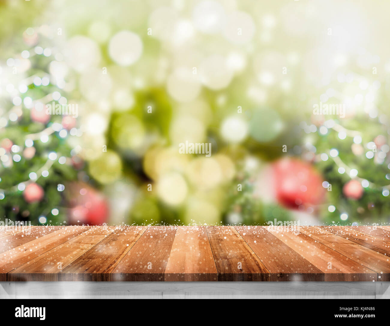 Svuotare tavolo in legno con abstract blur albero di natale e la caduta della neve con sfondo bokeh,sfondo vacanze,mock up banner per la visualizzazione del prodotto per Foto Stock