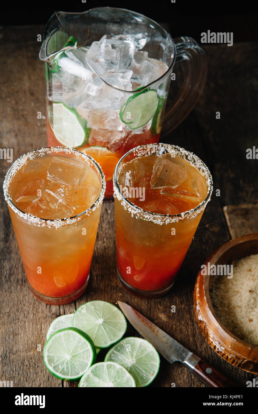 Una brocca di michelada con due bicchieri salate con RIM Foto Stock