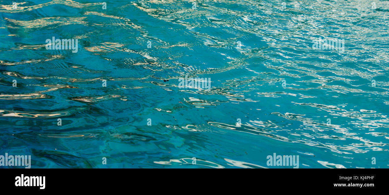 Acquamarina di acqua in una piscina esterna in estate è ideale per gli sfondi e sfondi con le sue gradazioni di tonalità e liquido toni ombrosi . Foto Stock