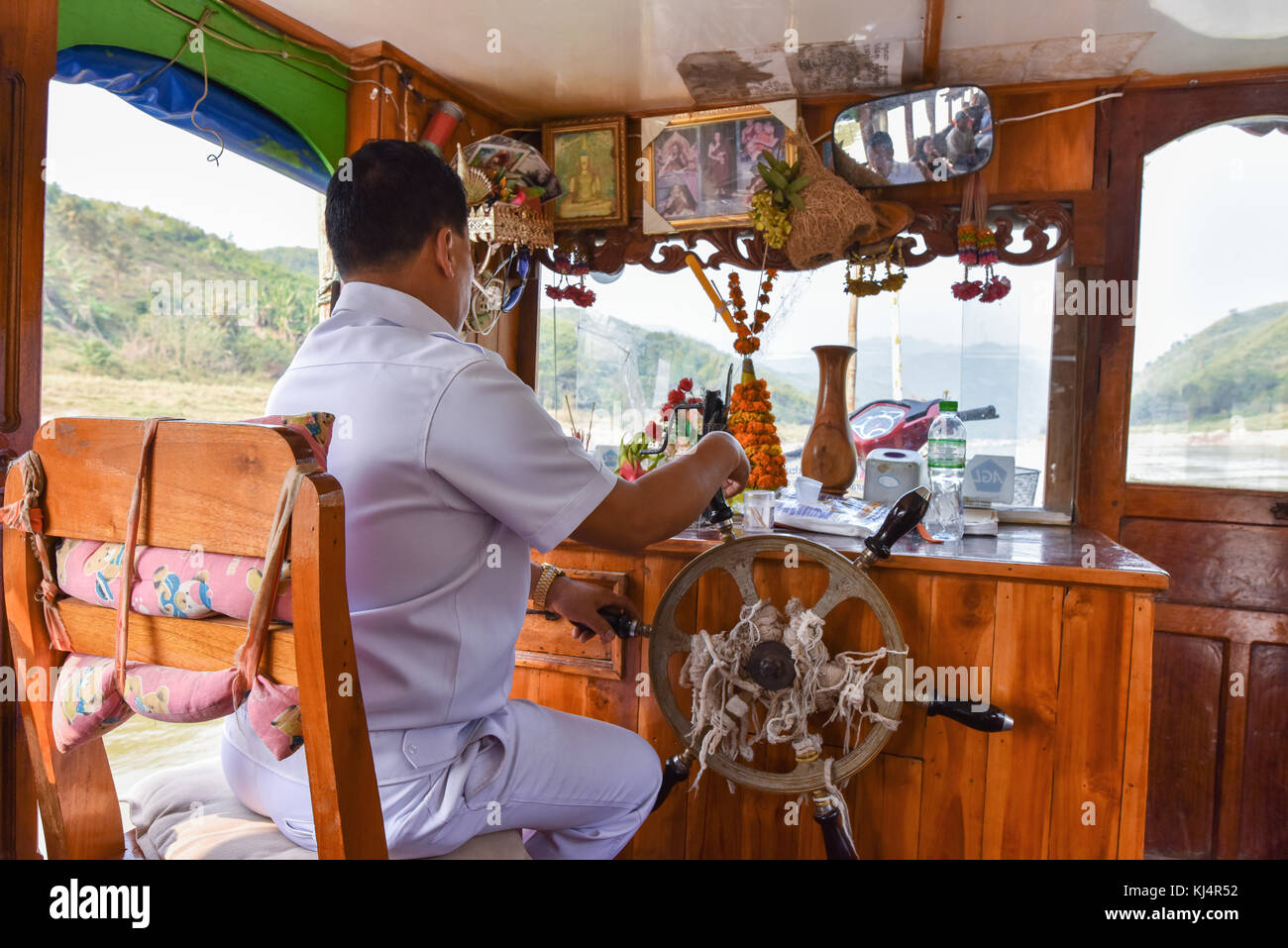 Il capitano di una barca lenta sul fiume Mekong Laos Foto Stock