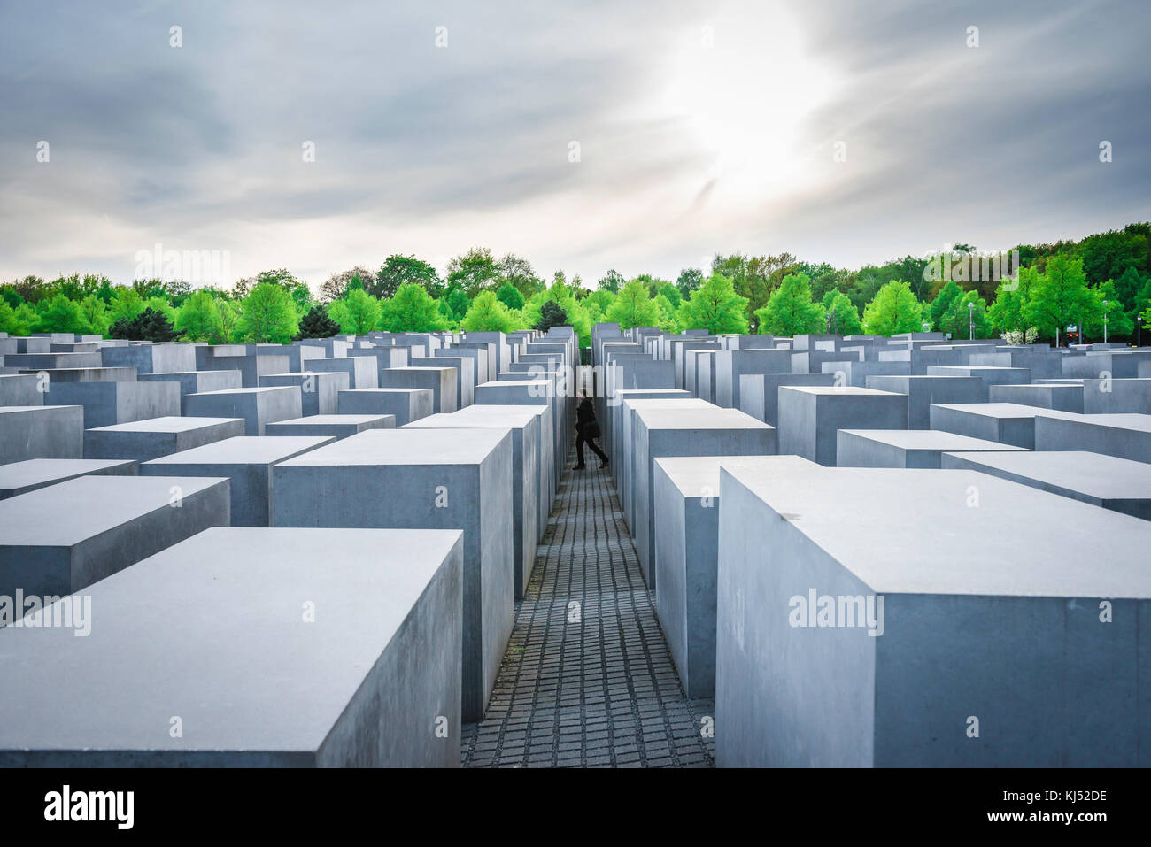 Memoriale dell'Olocausto di Berlino, vista di una passeggiata turistica tra gli enormi blocchi di pietra che compongono il Memoriale dell'Olocausto a Mitte, Berlino, Germania Foto Stock