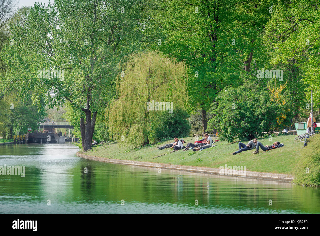 Berlino Tiergarten, vista dei giovani che si rilassano sulle rive del Landwehrkanal in un pomeriggio di primavera nel parco Tiergarten, Berlino, Germania. Foto Stock