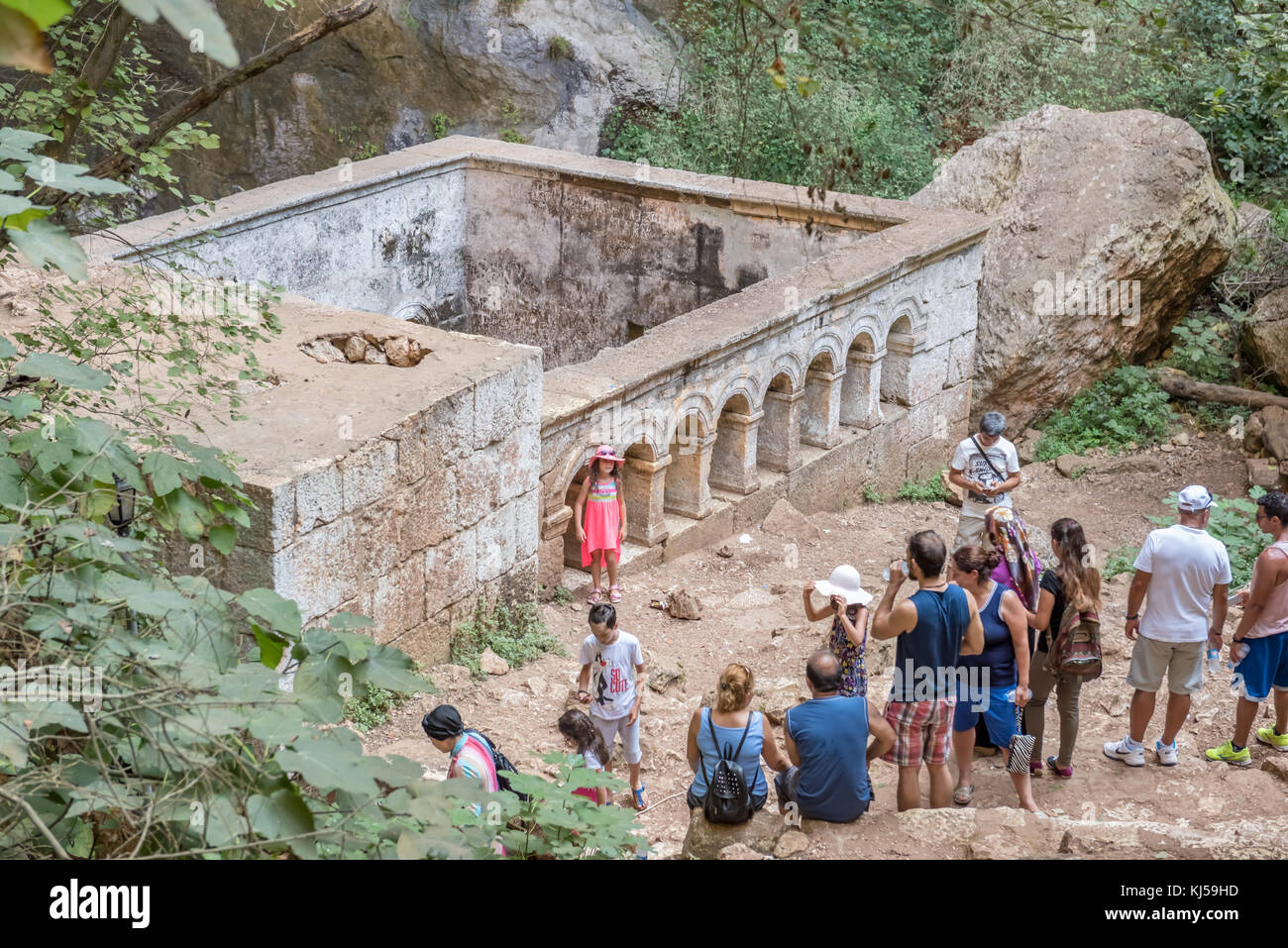 Persone non identificate andando giù per le scale di pietra verso la grotta della voragine di cielo nel quartiere silifke.st. Paulus cappella è in background.mersin turke Foto Stock