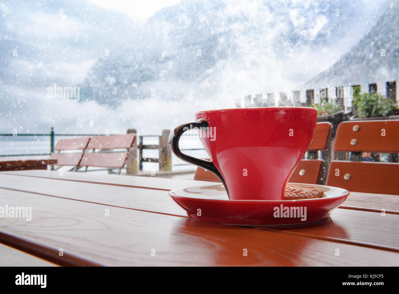 Momento di relax con una tazza di caffè caldo, su un tavolo in un ristorante austriaco, di Hallstatt, con una vista sui monti Dachstein, mentre nevicava Foto Stock