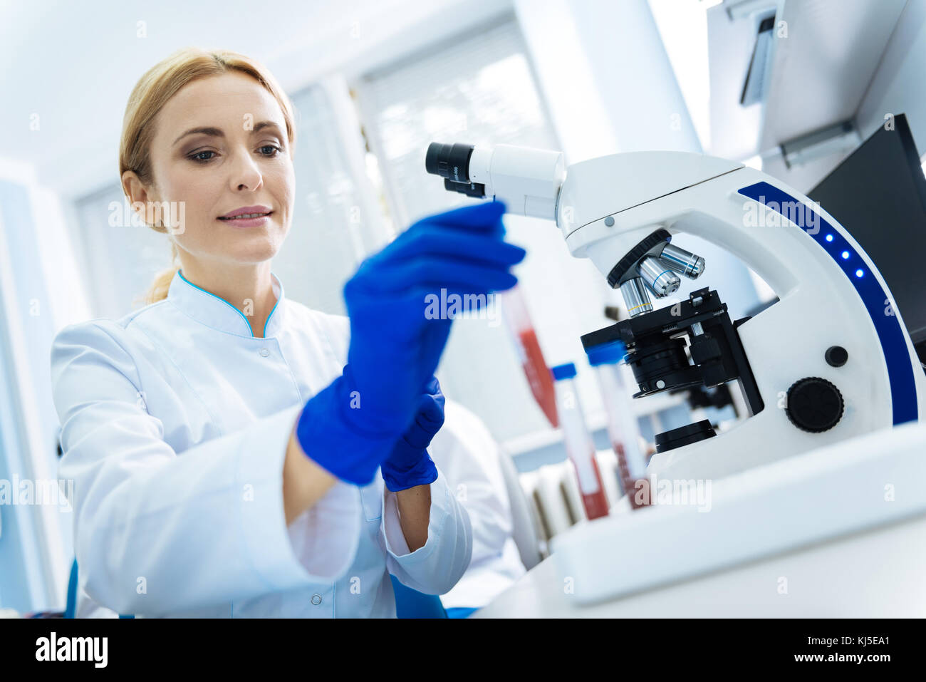 Scienziato di contenuti toccando il sangue di provette Foto Stock