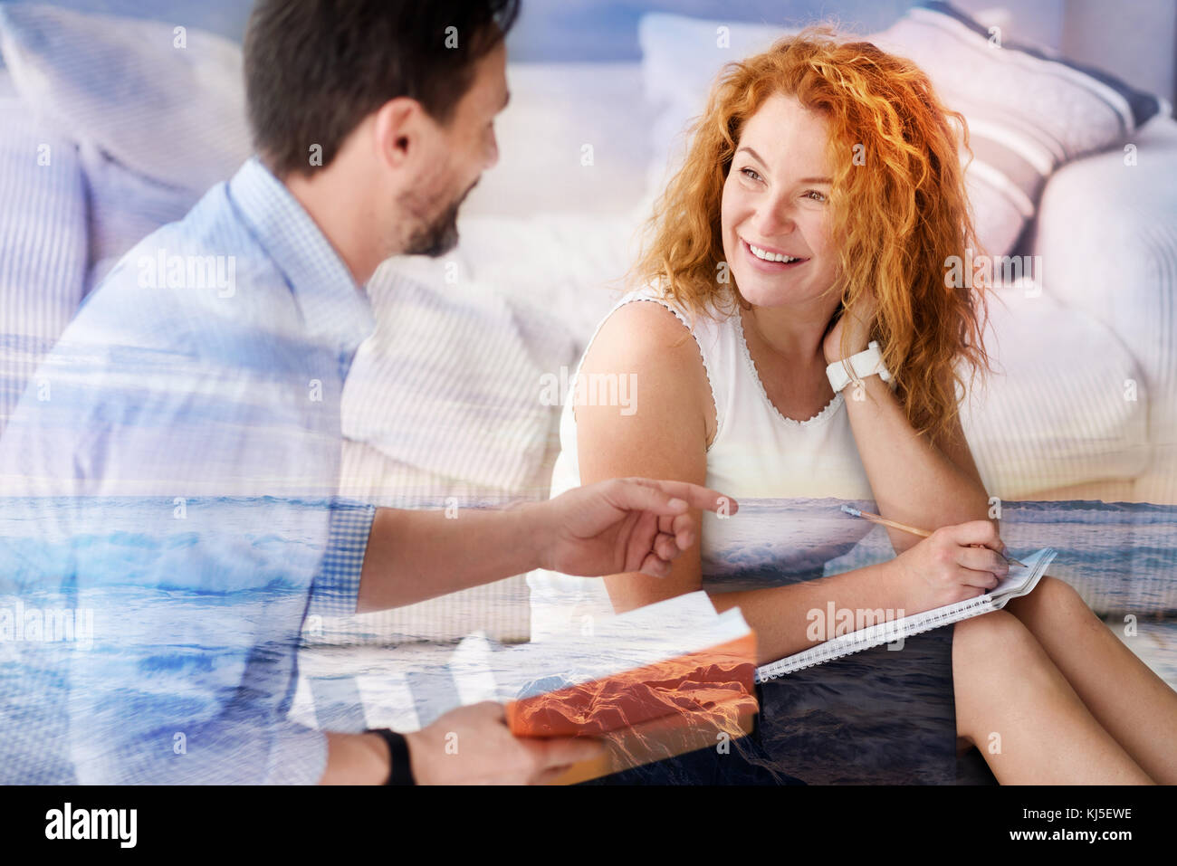 Lavoro positivo donna sorridente a un giovane uomo mentre a parlare con lui Foto Stock