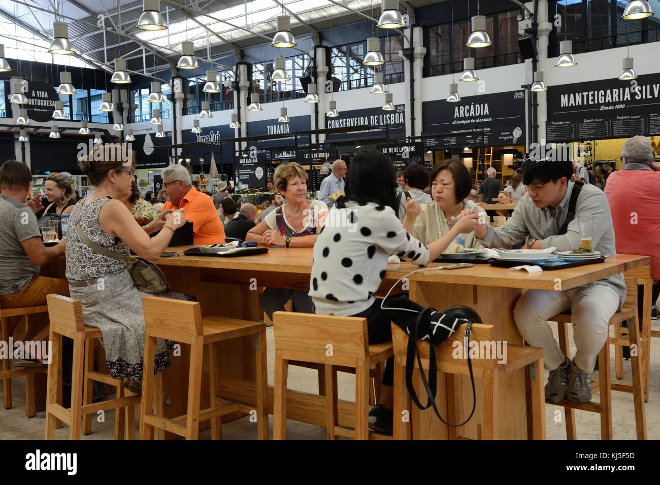 Persone mangiare all'interno del tempo storico fuori mercato food hall Mercado da Riberia Cais do Sodre Lisbona Foto Stock