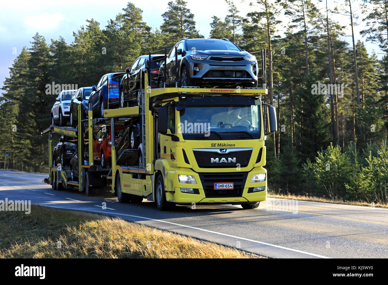 Salo, Finlandia - 17 novembre 2017: giallo Man tgs 18.420 auto vettore di sè makinen cale nuove vetture lungo l'autostrada nel tardo autunno. Foto Stock