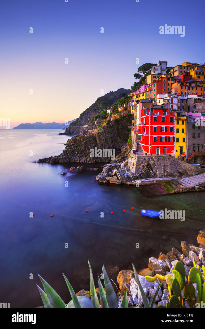 Riomaggiore villaggio sulla scogliera di rocce e mare al tramonto., Seascape in cinque terre, il Parco Nazionale delle Cinque Terre Liguria Italia Europa. Esposizione lunga Foto Stock