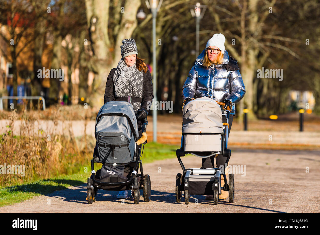 Vaxjo, Svezia - 13 novembre 2017: documentario della vita quotidiana e l'ambiente. due donne a spasso con le carrozzine su un soleggiato ma freddo mattino. Foto Stock