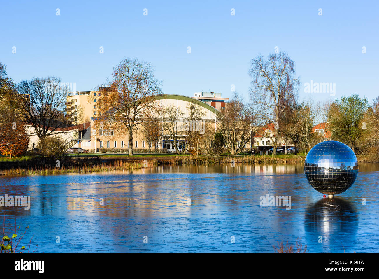 Vaxjo, Svezia - 13 novembre 2017: documentario della vita quotidiana e l'ambiente. rotante gigantesca palla da discoteca sul lago vaxjo con ghiaccio sottile che ricopre il Foto Stock