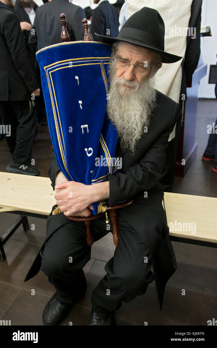 Un ortodosso hasidic rabbi può contenere un rotolo di Torah dopo che è stato letto e prima che sia stato restituito al Santo Ark. In Cambria Heights, Queens, a New York City Foto Stock