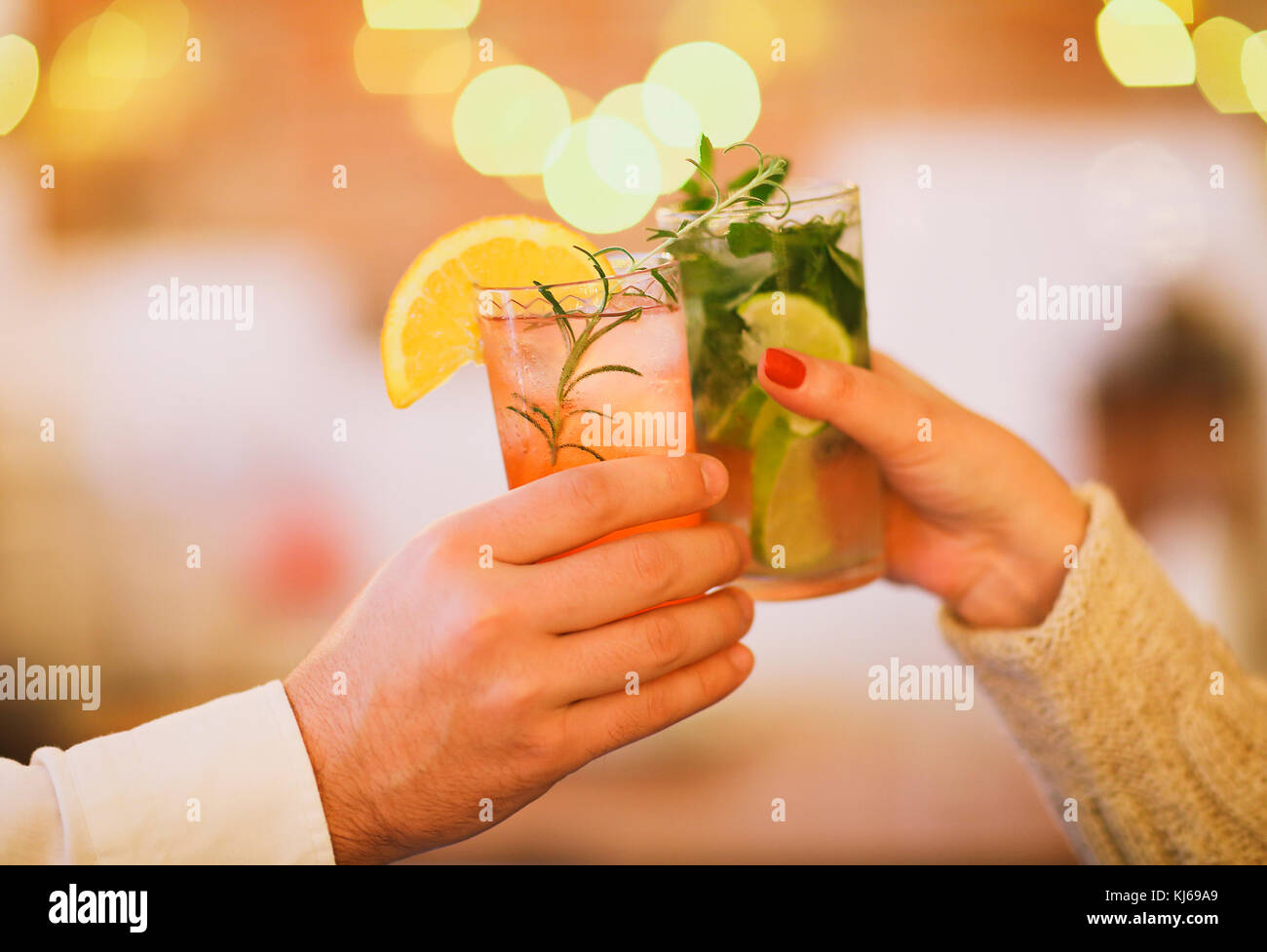 Due bicchieri da cocktail nell uomo e nella donna la mano. Close up Foto Stock