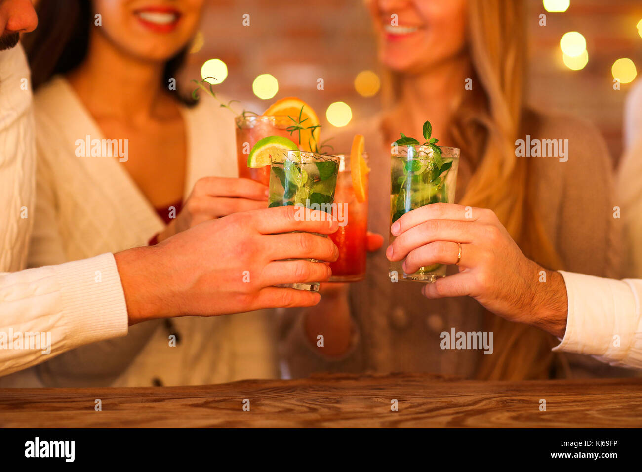 Giovani uomini e donne a bere cocktail a parte Foto Stock