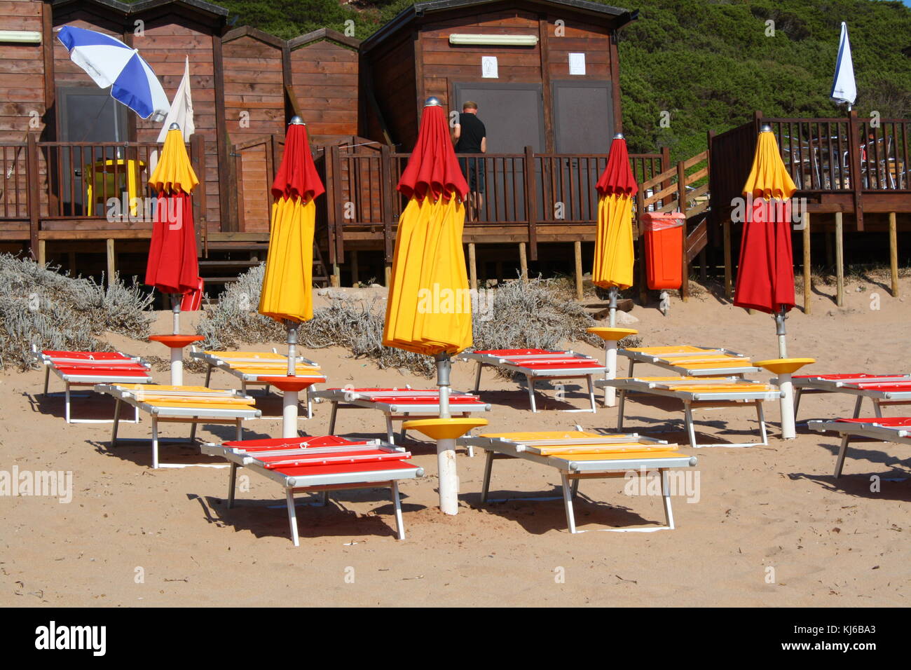 Chiuso ombrelloni e lettini su una spiaggia deserta fuori stagione. Foto Stock
