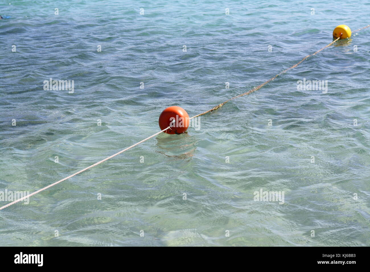 Una corda e una boa in acqua, come un separatore di barriera. Foto Stock