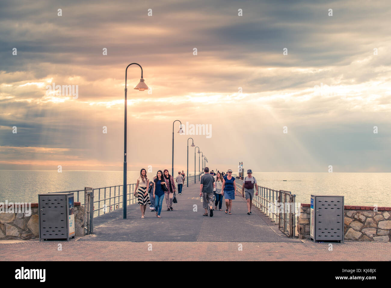 Adelaide, Australia - 19 gennaio 2016: la gente a piedi lungo il molo di glenelg al tramonto. molo è stata aperta per il pubblico il 25 aprile 1859 ed è uno dei più Foto Stock