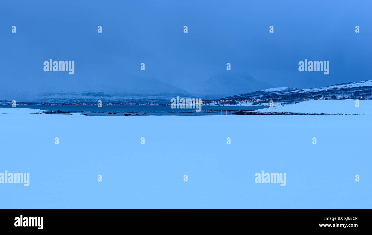 Le nuvole di un inverno mattina di gennaio. Paesaggi innevati. Le montagne e il mare in lontananza. Tisnes, Kvaløya, Tromsø, Norvegia. Foto Stock