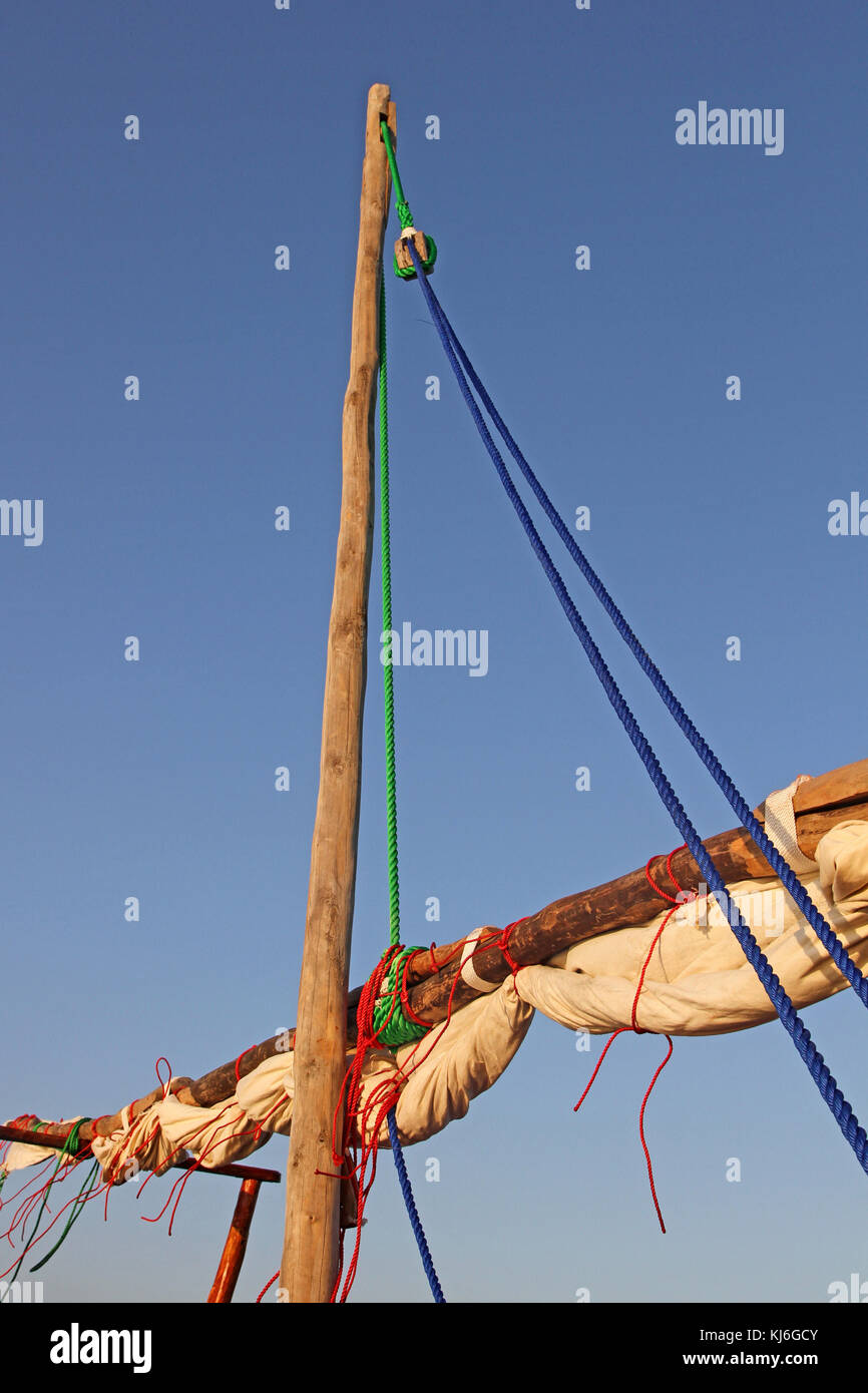 Barca montante riderhow con vela verso il basso e legato in su contro il cielo blu, Zanzibar, isola di Unguja, Tanzania. Foto Stock