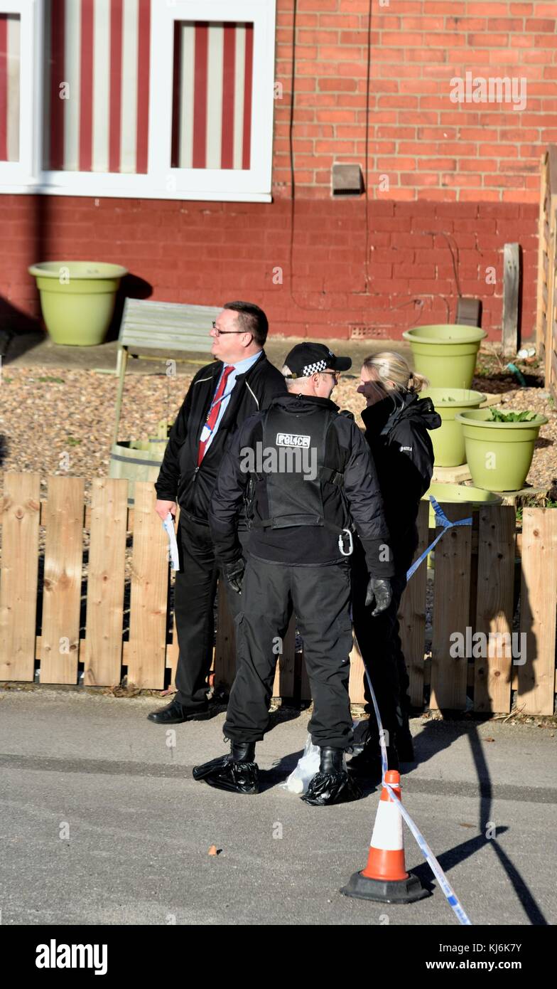 Poilce frequentando una scena del crimine indossando forensic sovrascarpe England Regno Unito Foto Stock