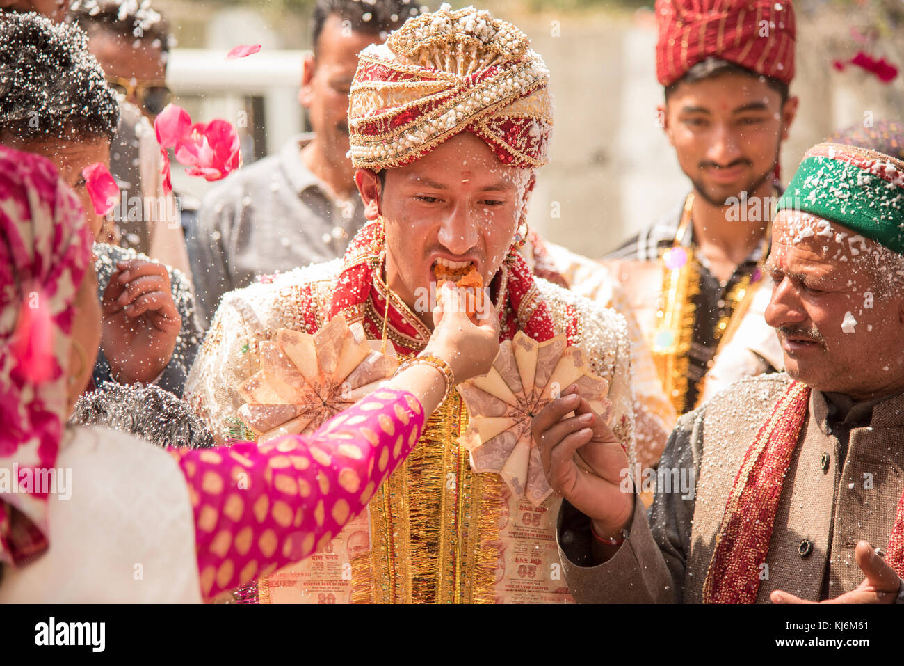 Shimla, India - 19 aprile 2017: la famiglia della sposa dolce di alimentazione per lo sposo come i suoi parenti, amici e famiglia guardare durante un matrimonio tradizionale in India Foto Stock