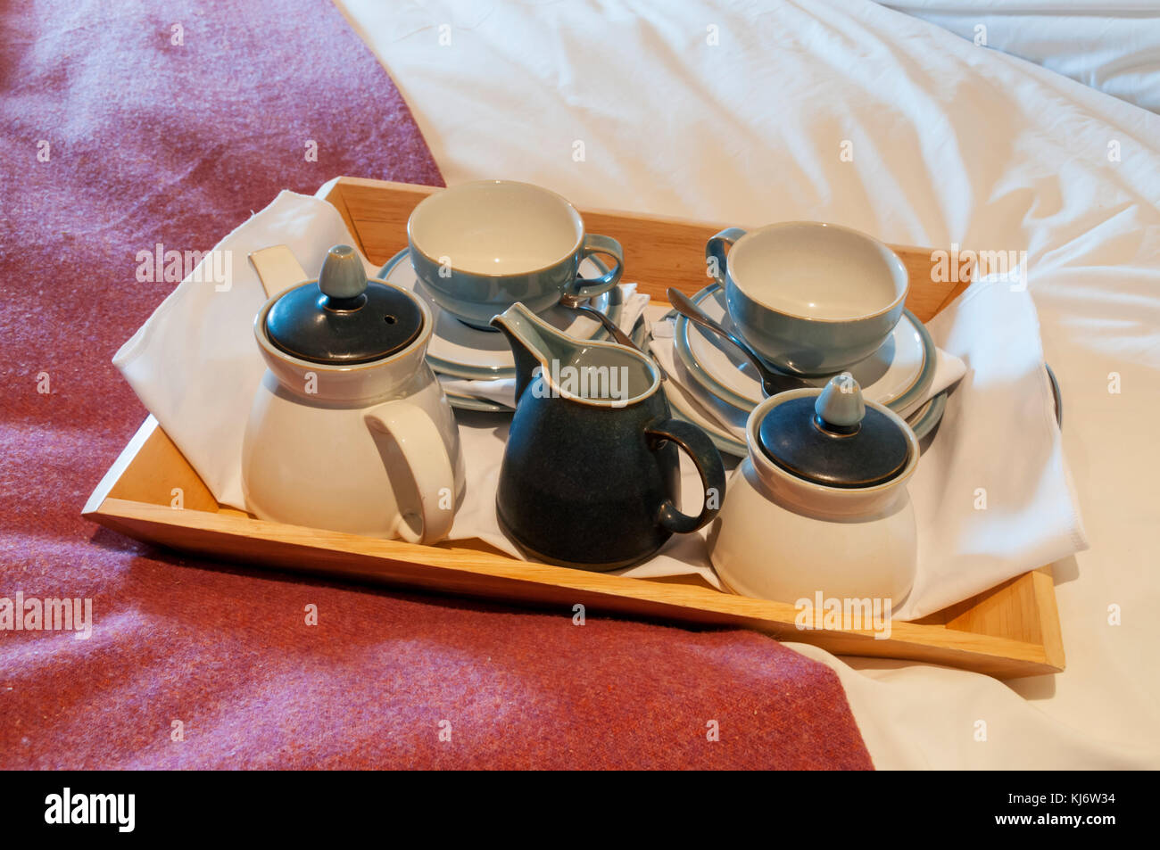 Tazze e piattini su un vassoio pronto per la colazione a letto. Foto Stock