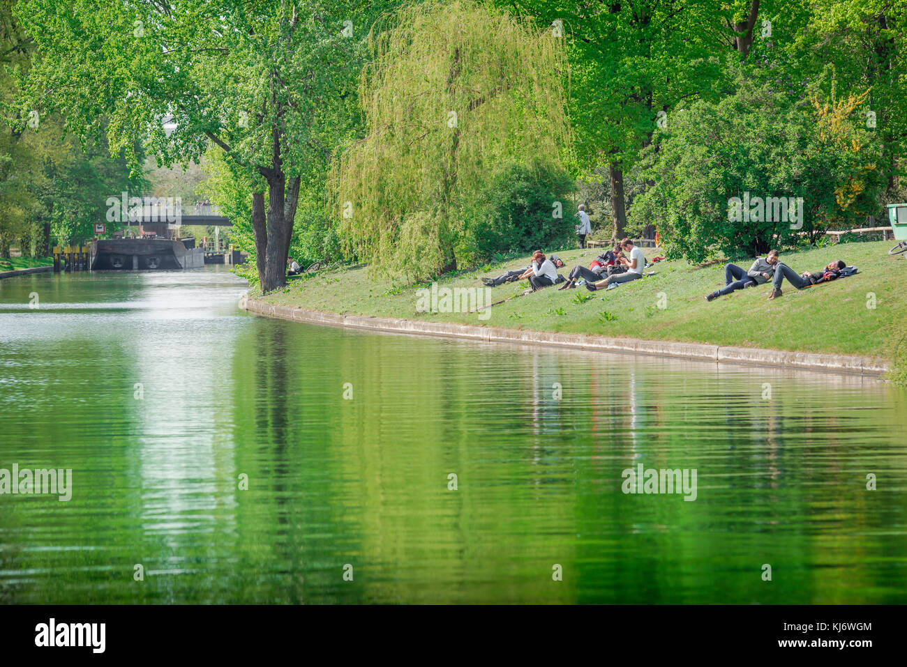 Fiume Berlino, vista dei giovani tedeschi che si rilassano sulle rive del Landwehrkanal in un pomeriggio di primavera nel parco Tiergarten, Berlino, Germania. Foto Stock