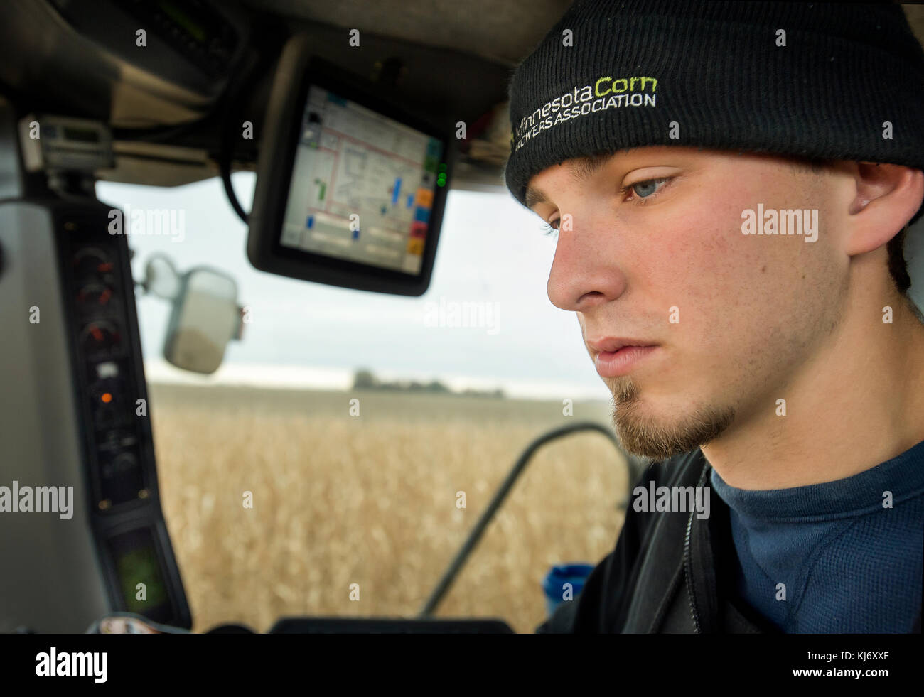 Ritratto di giovane agricoltore nella cabina della mietitrebbia, fioritura Prairie, Minnesota. Foto Stock