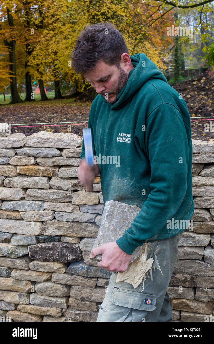 In pietra a secco parete essendo costruito in Bibury, Cotswolds, Gloucestershire, England, Regno Unito Foto Stock