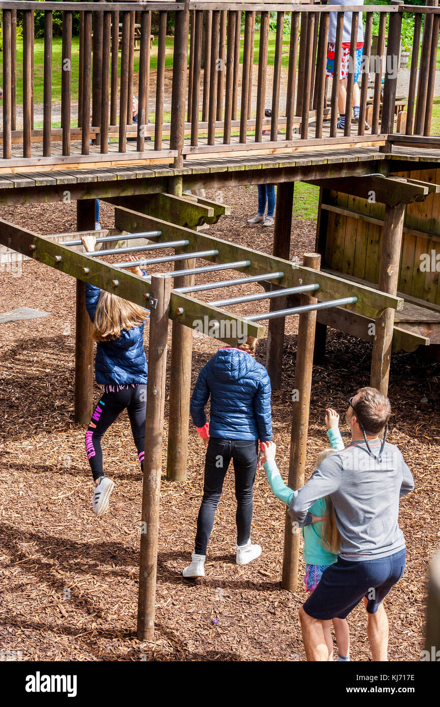 Bambini che giocano su barre di arrampicata in corteccia allentate parco giochi, Irlanda Foto Stock