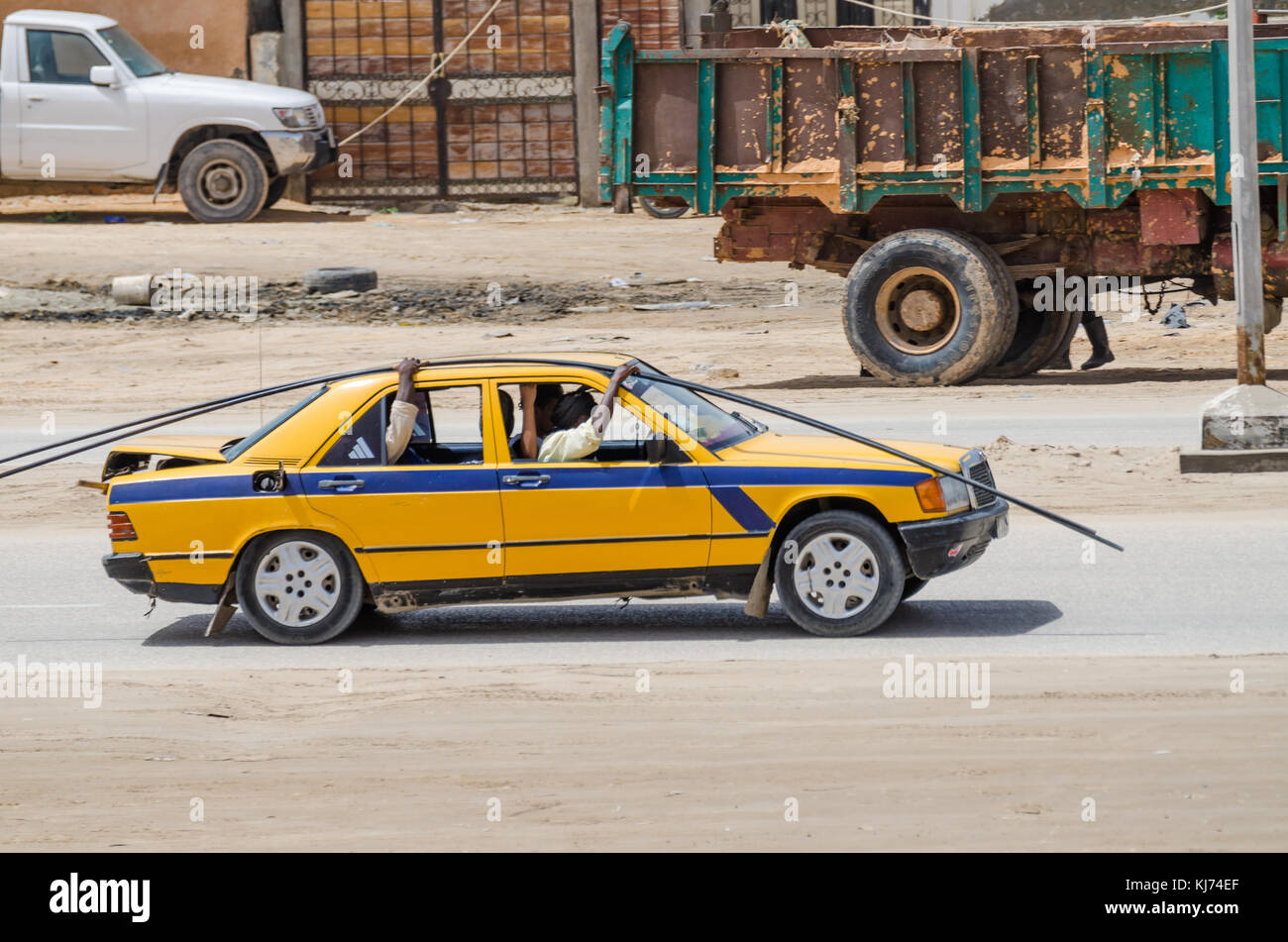 Nouakchott, Mauritania - Ottobre 08 2013: Street scene con aste in acciaio trasportati dal vecchio taxi Foto Stock