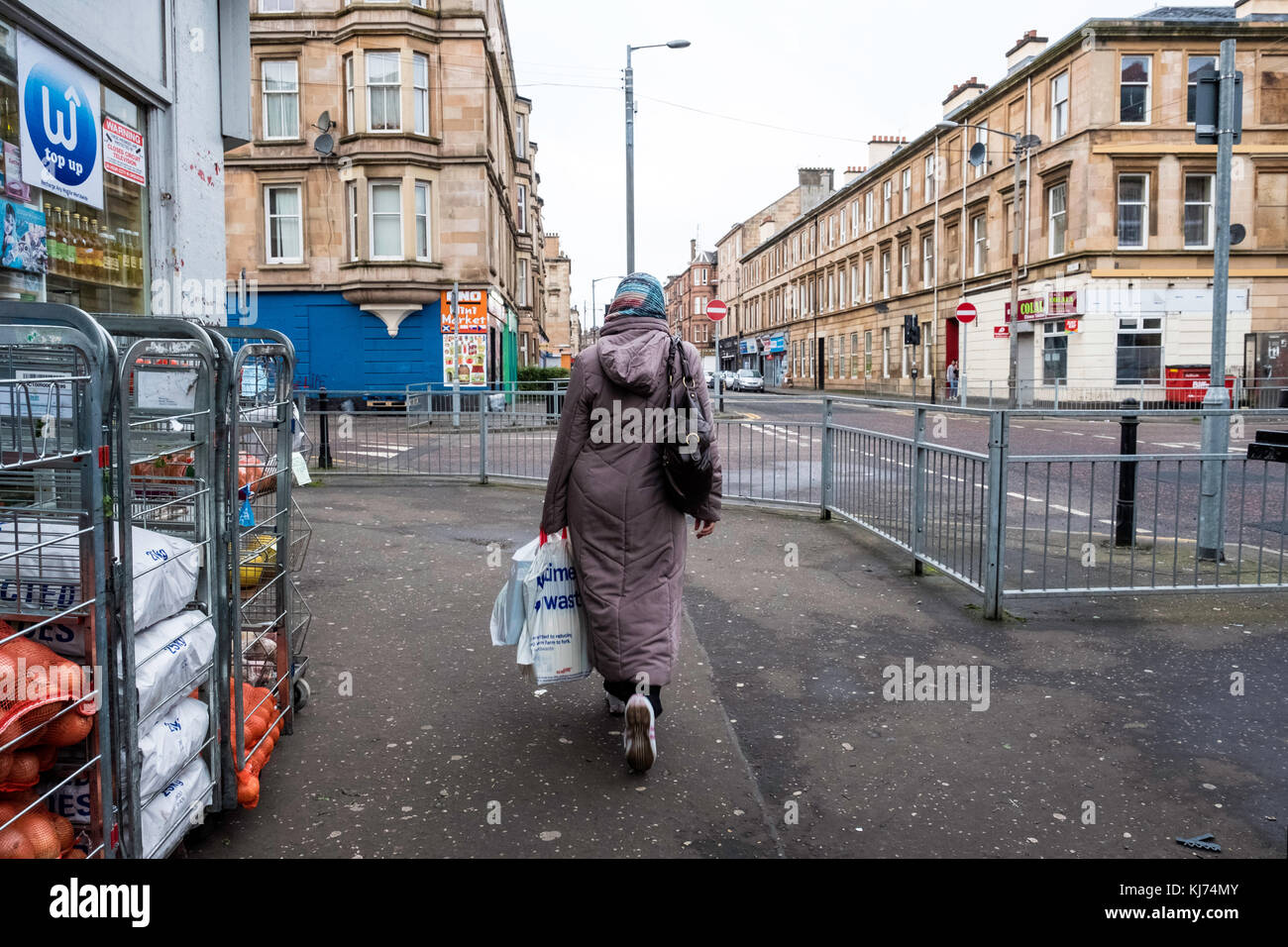 Donna musulmana strada a piedi nel quartiere Govanhill di Glasgow, Scozia, Regno Unito Foto Stock