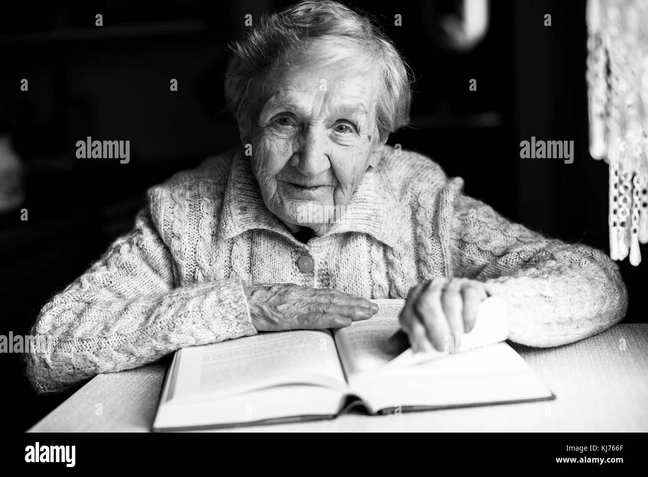Donna anziana la lettura di un libro in bianco e nero photo. Foto Stock