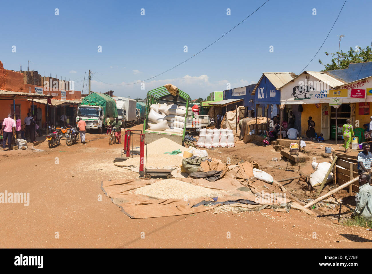 .Il Granturco di chicchi di mais disteso sul ciglio della strada per la vendita come ben è in grandi sacchi sul carrello, Uganda, Africa Foto Stock