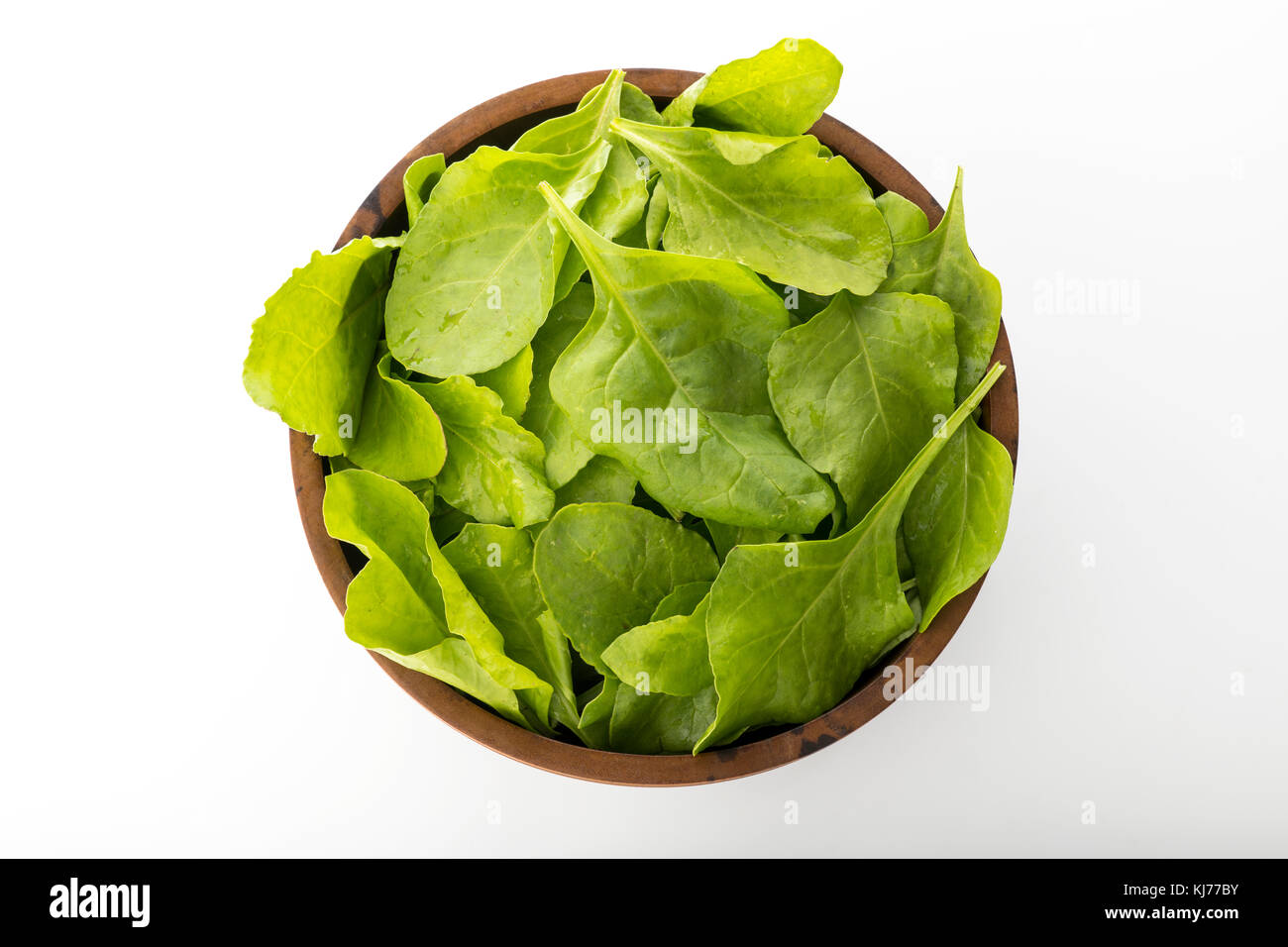 Vista superiore del fresco verde foglie di spinaci in ciotola di legno isolato su sfondo bianco Foto Stock