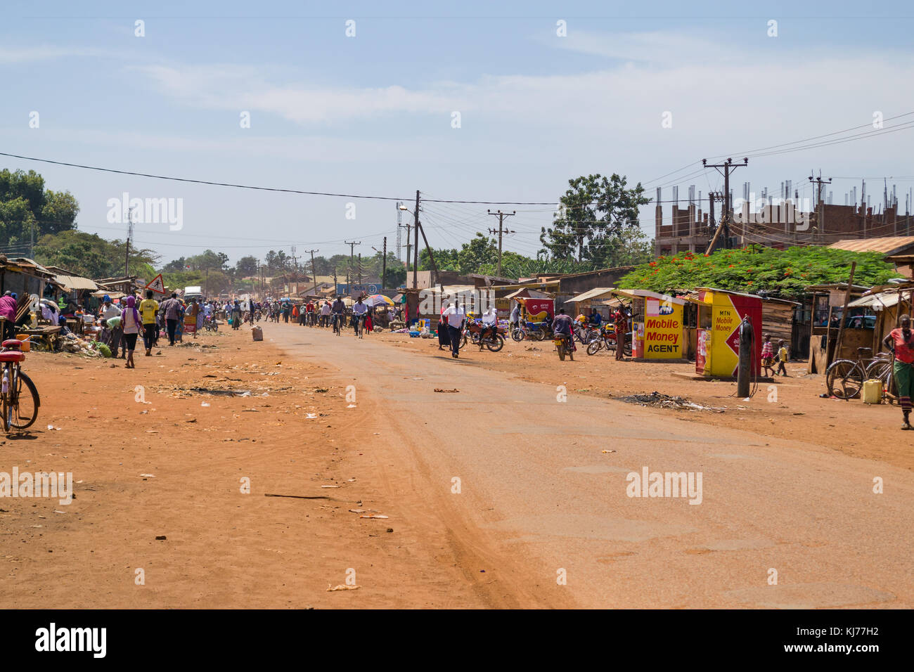 Una trafficata strada principale con la gente, bancarelle e negozi fodera, Busia, Uganda, Africa orientale Foto Stock