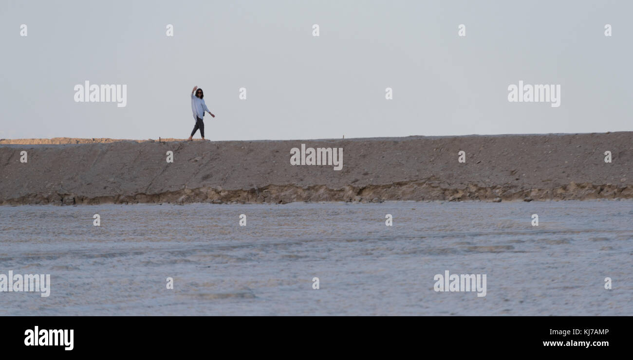 Donna che cammina sulla spiaggia, Mar Morto, Israele Foto Stock