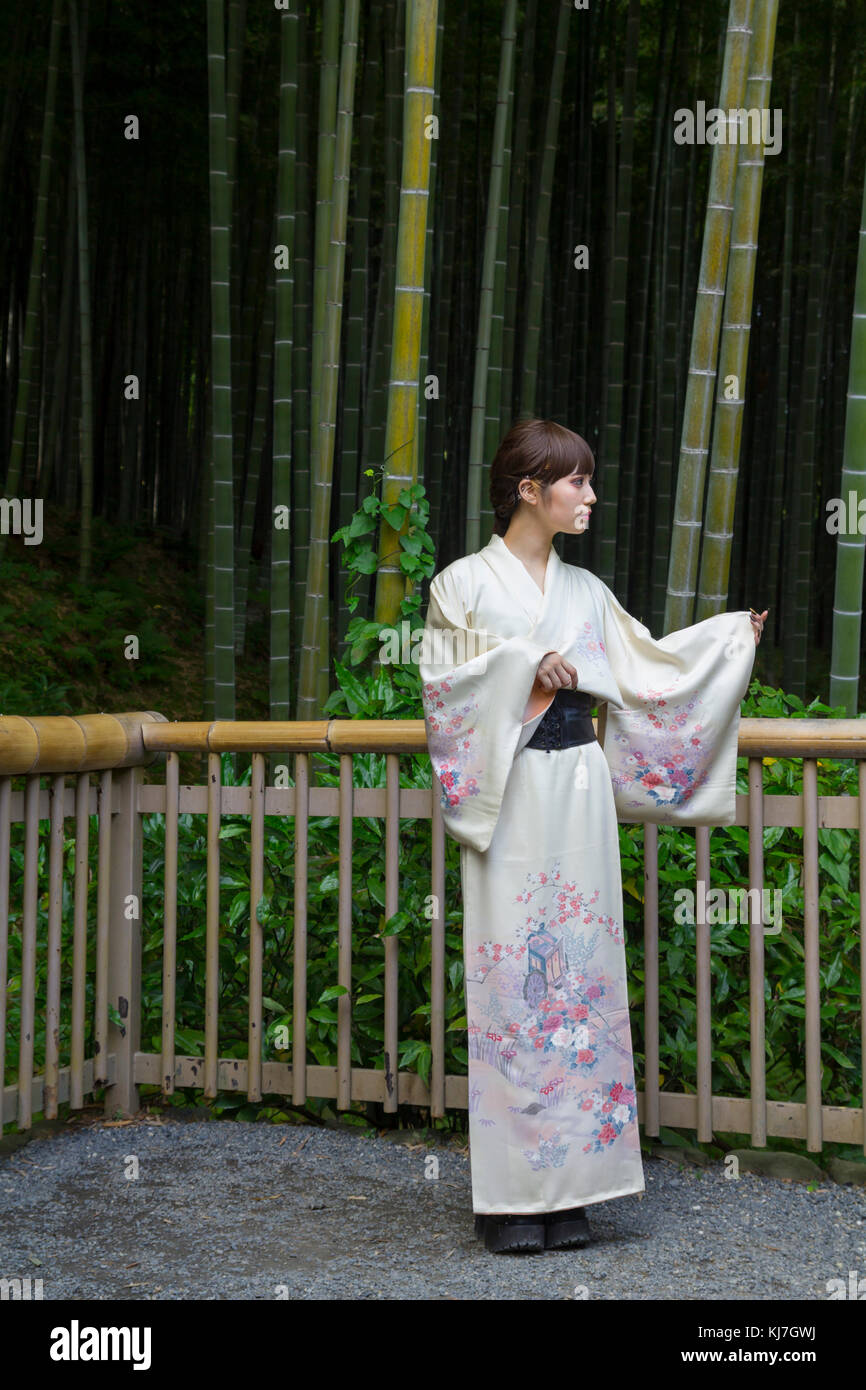 Giapponese giovane donna in kimono, di fronte a una foresta di bamboo a Kyoto, Giappone Foto Stock