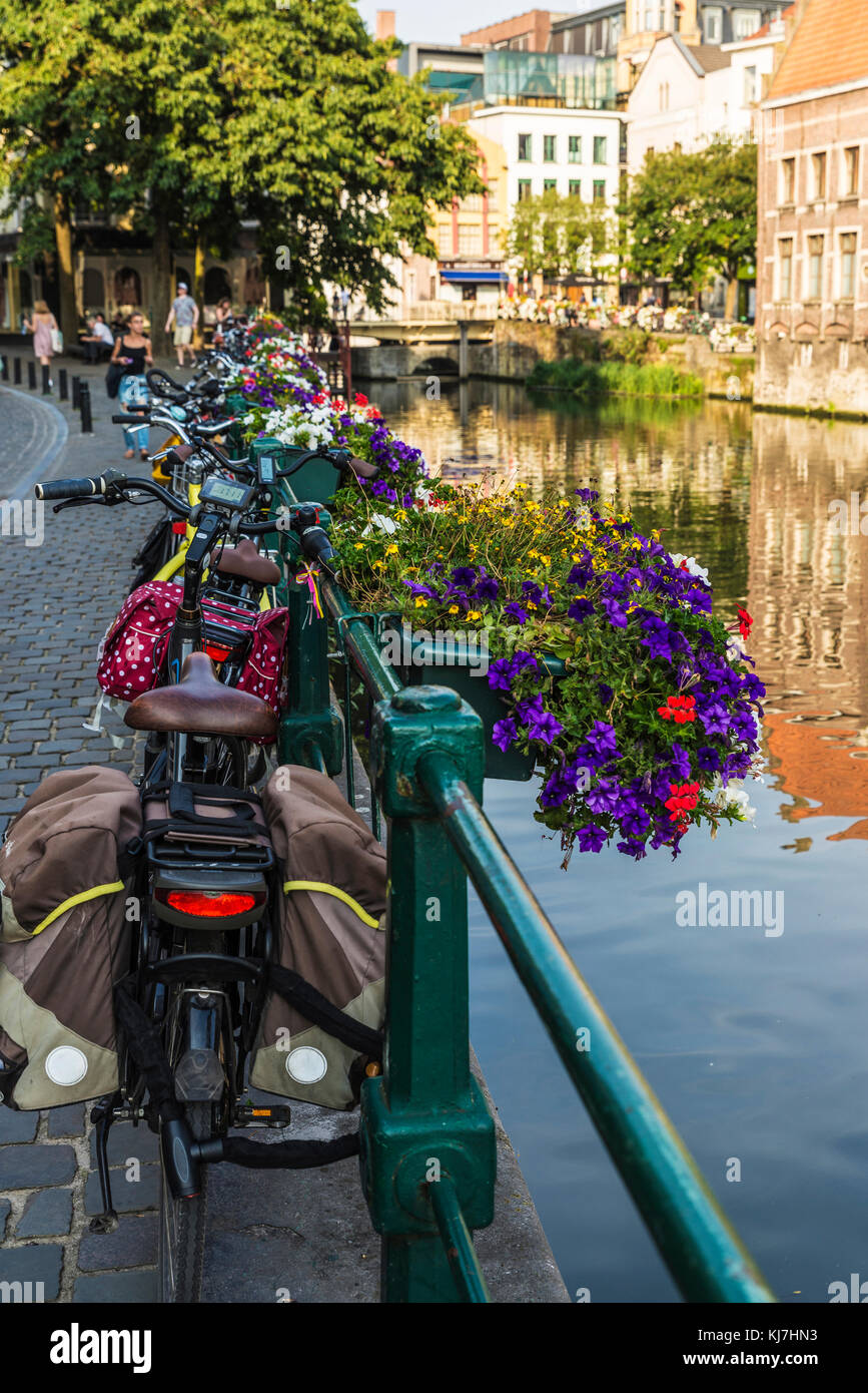 Ghent, Belgio - 28 agosto 2017: le biciclette parcheggiate e vaso di fiori lungo il fiume Leie nella città medievale di Gent, Belgio Foto Stock