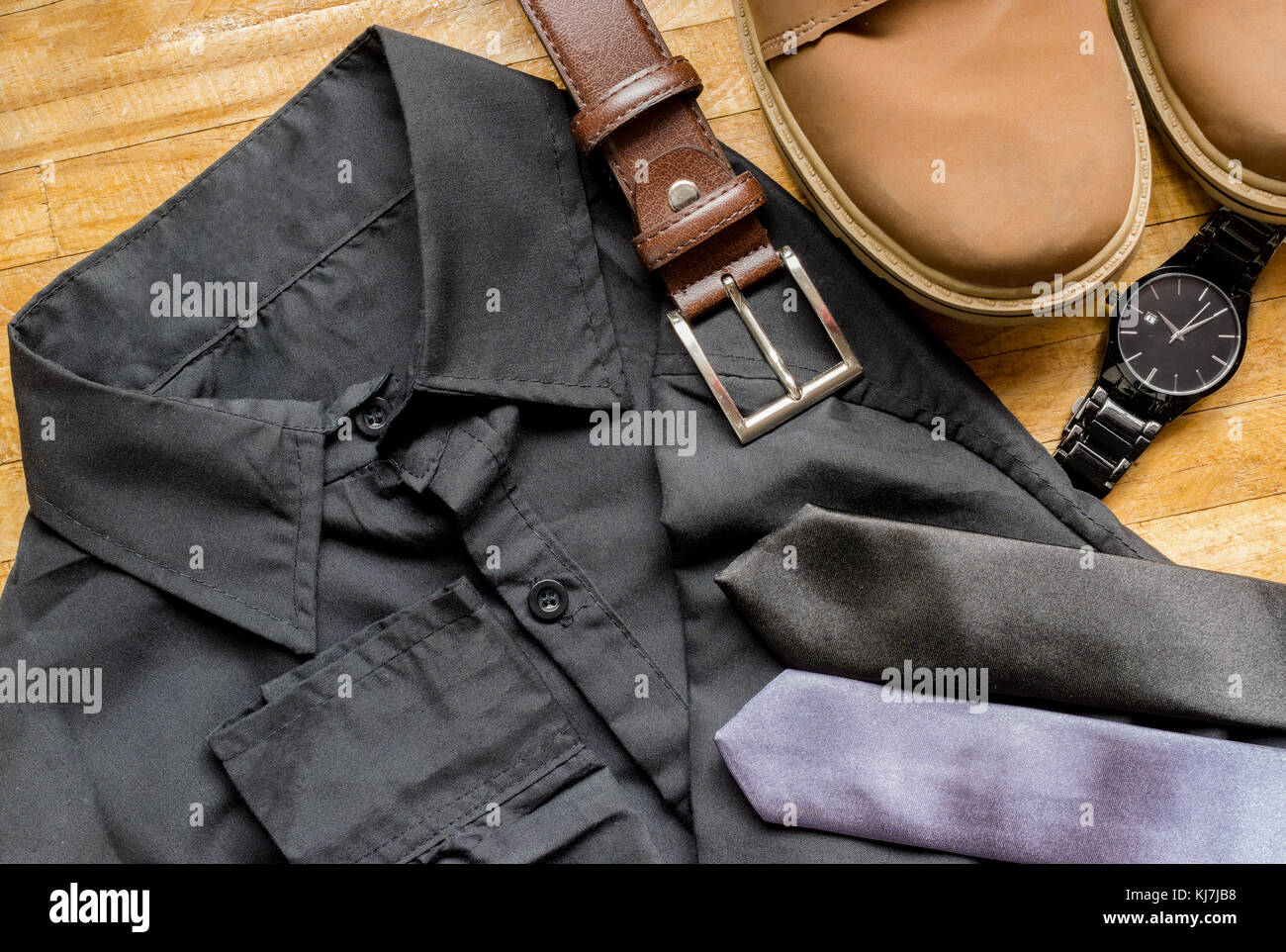 Abbigliamento uomo al di sopra di una superficie di legno, mostrando un  black dress shirt, marrone cintura in cuoio, marrone stivali, cravatte e  nero orologio da polso Foto stock - Alamy