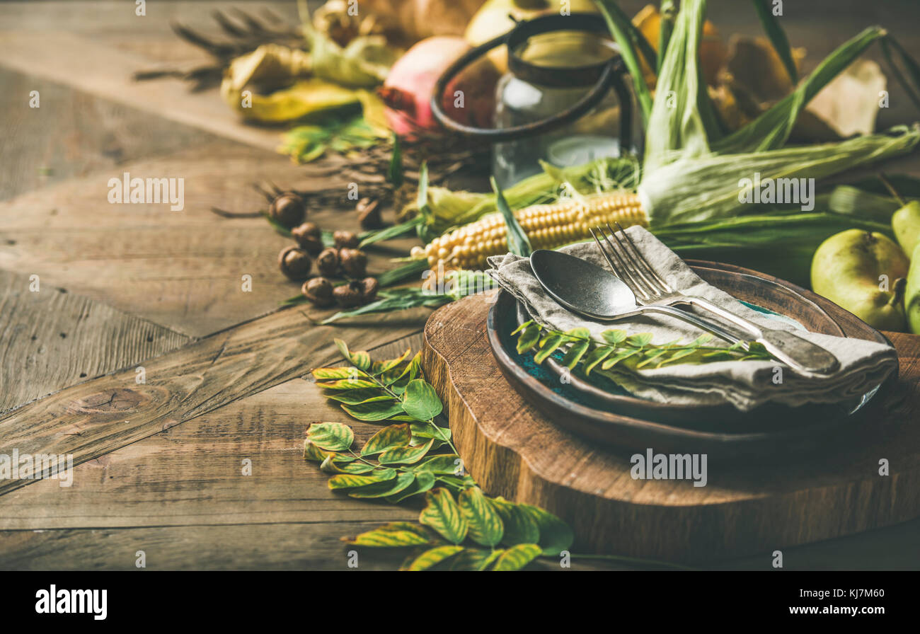 Caduta impostazione tabella per la celebrazione di ringraziamento. Flat-lay della piastra, posate, portacandele, Autunno di verdure di stagione e frutta e foglie cadute per de Foto Stock