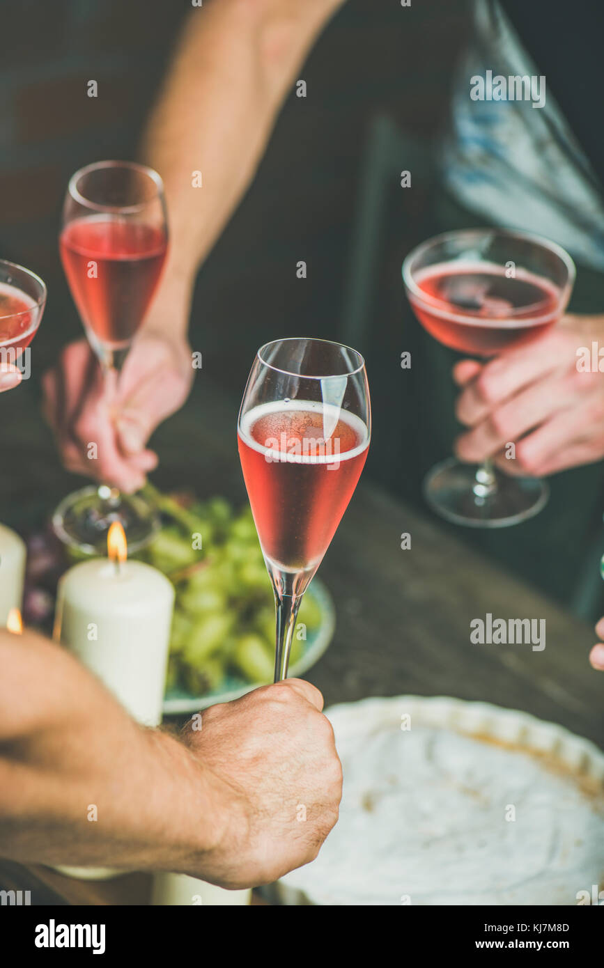 Per la festa di santa messa in tavola con il cibo. Gli amici le mani a mangiare e a bere insieme. Persone aventi una parte, raccolta, celebrando con rose champai Foto Stock